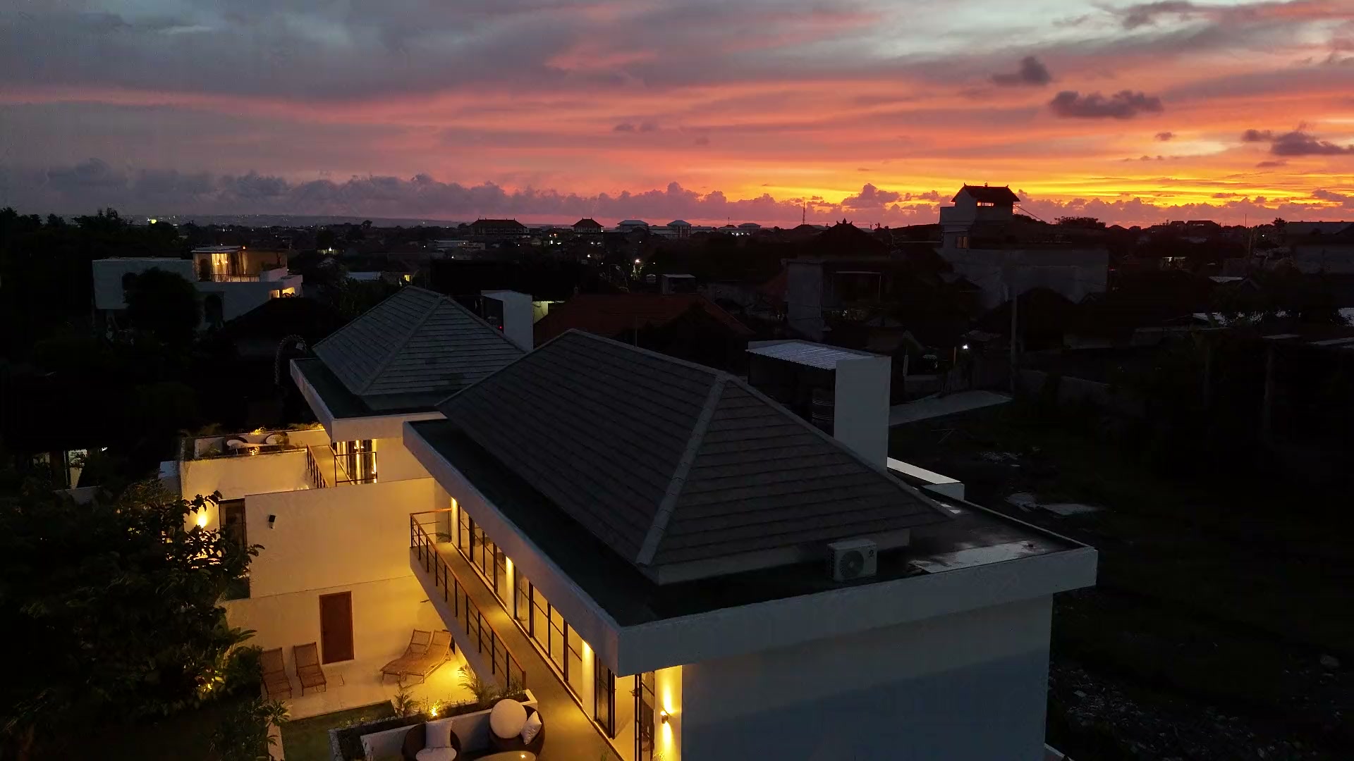 Aerial view of Villa Rice under a fiery sunset sky